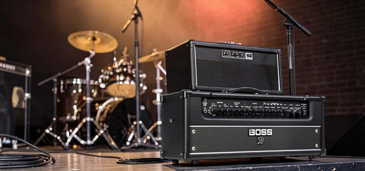 BOSS Katana Artist Head Gen 3 guitar amplifier on a speaker cabinet on a small club stage.